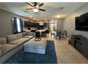 Well-lit living area with plush furniture, a large TV, and an open connection to the modern kitchen at 821 Lucent Sands Ct, Brandon, FL 33511