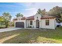 Charming home with a brown two-car garage, stucco facade, and well-maintained lawn on a sunny day at 8523 N Newport Ave, Tampa, FL 33604