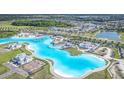 Expansive aerial view of community showcasing a large aqua lagoon, resort-style amenities, and surrounding neighborhood at 8812 Parsons Hill Blvd, Wesley Chapel, FL 33545