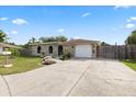 A quaint home features a stone facade, a one-car garage, and colorful flower beds enhancing its curb appeal at 8918 Carmen Ln, Port Richey, FL 34668