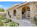 Detailed stone facade with arched entryways framing the tiled front porch entrance of this home at 8918 Carmen Ln, Port Richey, FL 34668