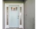 Elegant light blue front door with decorative glass and white trim, enhancing curb appeal at 94 Nicholas Dr, Dunedin, FL 34698