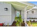 Welcoming front entrance with stylish door, elegant lighting, and lush landscaping around the entryway at 94 Nicholas Dr, Dunedin, FL 34698