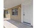 Close-up of front door with white trim, hardware, and adjacent window at 9915 Aetna Ln, Port Richey, FL 34668