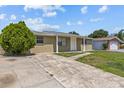 Single-story home with a well-worn driveway and a tidy, green front yard at 9915 Aetna Ln, Port Richey, FL 34668