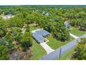 An aerial view of a single-Gathering home surrounded by trees, lush landscaping, and a large, paved driveway at 10197 Meadow Wren Ave, Weeki Wachee, FL 34613