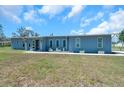 Charming single-story home with a light blue exterior, well-maintained lawn, and neatly trimmed landscaping at 10722 Sumner Rd, Wimauma, FL 33598
