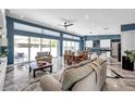 Bright, open living room with modern lighting, high ceilings, expansive windows, and an elegant tile floor at 10722 Sumner Rd, Wimauma, FL 33598