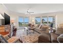 Comfortable living room featuring large windows with ocean views, a ceiling fan, and classic furnishings at 1180 Gulf Blvd # 402, Clearwater Beach, FL 33767
