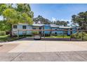 Condo exterior with parking area, lush greenery, and mature trees at 11800 Park Blvd # 208, Seminole, FL 33772
