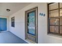 Hallway view of unit 208 with a gray front door and well-lit area at 11800 Park Blvd # 208, Seminole, FL 33772