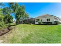 Large backyard with lush green grass and view of screened-in pool area at 11938 Royce Waterford Cir, Tampa, FL 33626