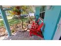 Cozy front porch adorned with vibrant red chairs, offering a perfect spot for relaxation at 12176 Croft Dr, Largo, FL 33774