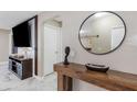 Stylish entryway featuring a modern console table, round mirror, and elegant marble flooring at 1406 Valley Pl, Brandon, FL 33510