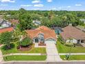 An aerial shot showcasing this well-maintained home with a two-car garage, complemented by lush green surroundings at 14103 Stonebrook Ct, Tampa, FL 33624