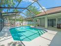 Refreshing screened-in pool with modern tiling, creating a backyard oasis ideal for entertaining or quiet enjoyment at 14103 Stonebrook Ct, Tampa, FL 33624