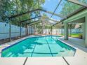 Sparkling screened-in pool with bright blue tiling, set in a peaceful, private backyard perfect for relaxation at 14103 Stonebrook Ct, Tampa, FL 33624