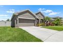 View of a home featuring an attached two-car garage, manicured lawn, and a charming front yard at 1517 Yale Castle Ct, Ruskin, FL 33570
