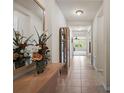 Welcoming hallway featuring tile flooring, a decorative mirror, and views into other rooms at 1517 Yale Castle Ct, Ruskin, FL 33570