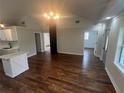 Spacious living room with vaulted ceilings, hardwood floors, and a modern lighting fixture at 18127 Us Highway 41, Spring Hill, FL 34610