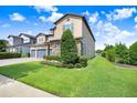 Beautiful lawn on this two-story home featuring a three-car garage with stone accents at 18824 Birchwood Groves Dr, Lutz, FL 33558