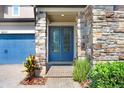 Charming front entrance with stone accents, a brick walkway and a blue double door at 18824 Birchwood Groves Dr, Lutz, FL 33558