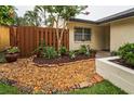 Landscaped front yard featuring mature trees, shrubbery, rocks, and colorful brick accents at 1948 Elaine Dr, Clearwater, FL 33760