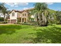 This home features a brick driveway, a manicured lawn, and lush landscaping at 19711 Wellington Manor Blvd, Lutz, FL 33549