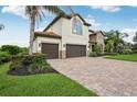 This home features a brick driveway, a manicured lawn, and a three-car garage at 19711 Wellington Manor Blvd, Lutz, FL 33549