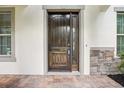 The home boasts a beautiful dark wood front door with stone accents at 19711 Wellington Manor Blvd, Lutz, FL 33549
