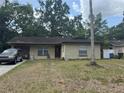 Tan single-story home with a brown front door and two windows, and a car parked in the driveway at 201 Lentz Rd, Brandon, FL 33510