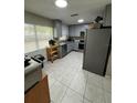 An all-grey kitchen features stainless steel appliances, gray cabinets, and a window with blinds at 201 Lentz Rd, Brandon, FL 33510