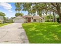 Beautiful single-story home with manicured lawn, an attached garage and an inviting red front door at 206 Forest Wood Ct, Spring Hill, FL 34609