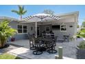 Outdoor dining area with shaded umbrella perfect for entertaining in the landscaped backyard at 2271 Carolyn Dr, Dunedin, FL 34698