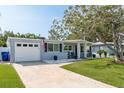 Charming single-story home with a well-manicured lawn and an attached garage on a sunny day at 2271 Carolyn Dr, Dunedin, FL 34698