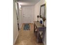 Bright condo foyer featuring neutral tile flooring, a console table with lamps, and a decorative rug at 240 N Bayshore Blvd # 102, Clearwater, FL 33759