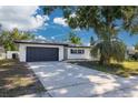 Charming single-story home with a well-maintained lawn, mature trees, and a two-car garage at 2436 Beacon Groves Blvd, Palm Harbor, FL 34683