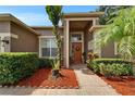 Inviting front entrance featuring a beautifully landscaped walkway leading to a welcoming front door and manicured shrubbery at 2803 Abbey Grove Dr, Valrico, FL 33594