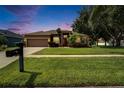 Charming home featuring a well-maintained lawn, mature landscaping and a classic mailbox in a serene setting at 2803 Abbey Grove Dr, Valrico, FL 33594