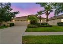 Charming one-story home with a two-car garage and beautiful lawn under a colorful sky at 3302 Granite Ridge Loop, Land O Lakes, FL 34638