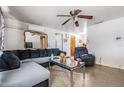 Cozy living room featuring a comfortable sectional sofa, ceiling fan, and decorative mirror above the couch at 4527 W Minnehaha St, Tampa, FL 33614