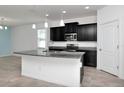 Stylish kitchen with sleek black cabinetry, stainless steel appliances, and a center island at 5446 Suncatcher Dr, Wesley Chapel, FL 33545