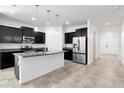 Modern kitchen with dark cabinets, stainless steel appliances, and a large center island with granite countertops at 5446 Suncatcher Dr, Wesley Chapel, FL 33545