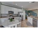 Bright eat-in kitchen featuring stainless steel appliances, granite countertops, and white cabinetry at 580 Shoreham Ne Ct, St Petersburg, FL 33716