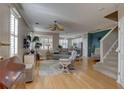 Inviting living room with hardwood floors, a ceiling fan, and ample natural light from shuttered windows at 580 Shoreham Ne Ct, St Petersburg, FL 33716