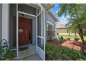 Inviting entryway featuring a stylish front door, screen door, and decorative landscaping adding to curb appeal at 5925 Sweet William Ter, Land O Lakes, FL 34639