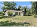 Quaint one-story home with a lush green lawn and mature trees providing shade and privacy at 5960 Boyette Rd, Wesley Chapel, FL 33545