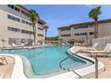 Inviting community pool surrounded by lounge chairs and white fencing, nestled between condo buildings at 6370 1St N St # 202, St Petersburg, FL 33702