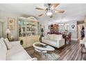 Open-concept layout showcases a living room with a decorative hutch, wood flooring, and a ceiling fan at 7523 Pitch Pine Cir # 184, Tampa, FL 33617