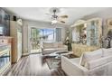 Bright living room featuring wood flooring, a ceiling fan, and sliding door access to an outdoor balcony at 7523 Pitch Pine Cir # 184, Tampa, FL 33617